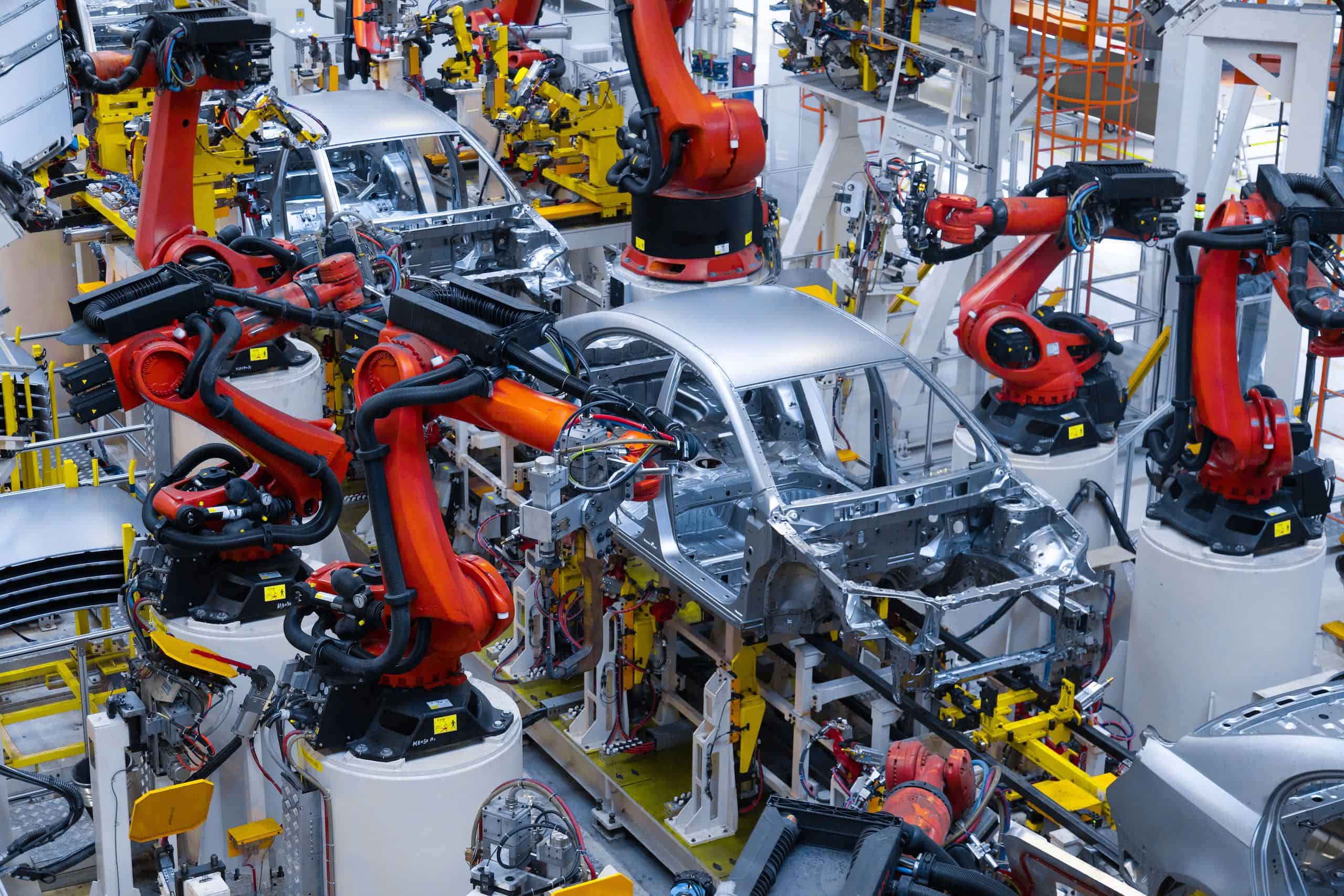 Protección de línea de producción de automóviles nuevos con un regulador de voltaje industrial. Soldadura automatizada de la carrocería del automóvil en la línea de producción. El brazo robótico en la línea de producción de automóviles está funcionando